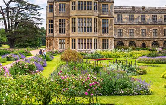A view of Audley End House with the flower beds in the foreground.