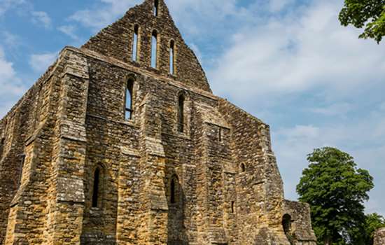 A low angle view of Battle Abbey underneath a blue sky.
