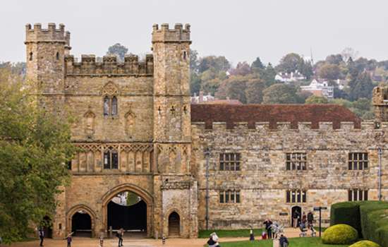 A view of Battle Abbey with people walking in the grounds.
