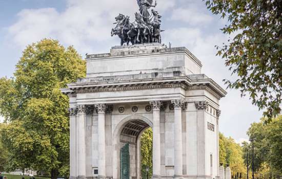 A grand white arch with a large statue on top